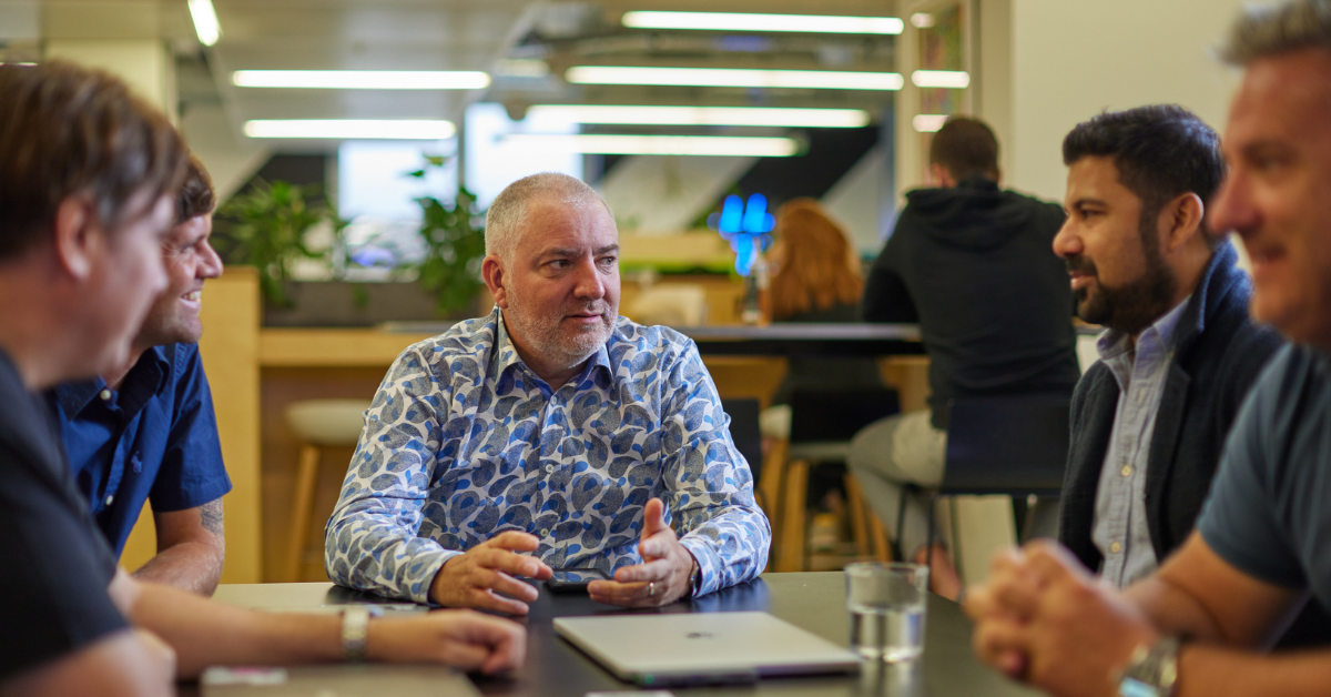 Peter and the Multiply team talking around a table.